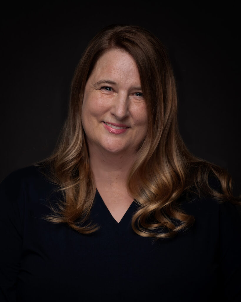 A smiling woman with long brown hair.